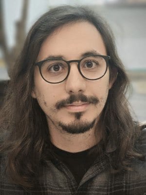 João sitting at a bench, similing at the camera